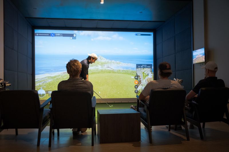 Venner spiller golf i simulatoren